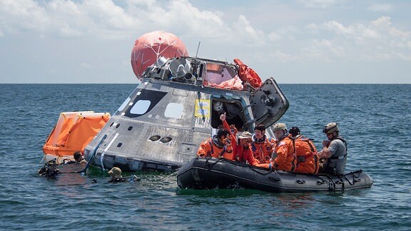 Raumkapsel im Meer, Schlauchboote mit mehreren Menschen