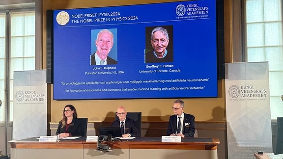 Auf der Leinwand während der Pressekonferenz zur Bekanntgabe des Physik-Nobelpreises 2024 werden Bilder des US-amerikanischen Physikers John Hopfield (l) und des kanadischen Forschers Geoffrey Hinton gezeigt. 