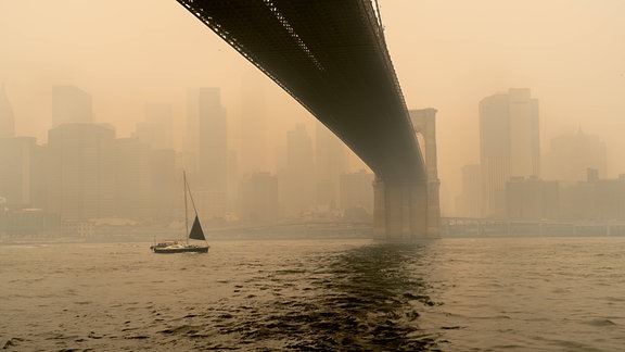 Blick unter der Brooklyn Bridge in Brooklyn, N.Y. USA, auf einen rauchigen Dunstschleier, der NYC am Mittwoch, den 6. Juni 2023 durch kanadische Waldbrände einhüllte.