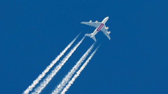 Ein Flugzeug von Emirates Airbus A380 mit Kondensstreifen am blauen wolkenlosen Himmel.