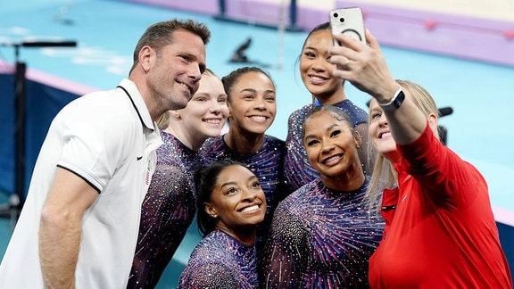Die US-amerikanische Kunstturnerin Simone Biles (C, unten) posiert während einer offiziellen Trainingseinheit in der Bercy Arena in Paris am 25. Juli 2024 vor den Olympischen Spielen in Paris für ein Foto.