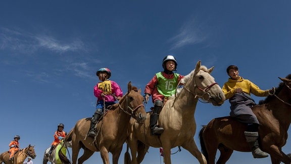 Junge Reiter bei einem Pferderennnen in der Mongolei.