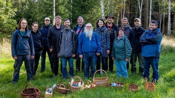 Menschen stehen im Wald nebeneinander