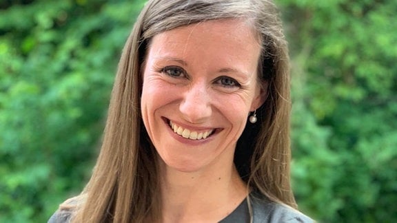 Die Wissenschaftlerin Julia Hartmann, eine Frau mit langen braunen Haaren, lächelt in die Kamera