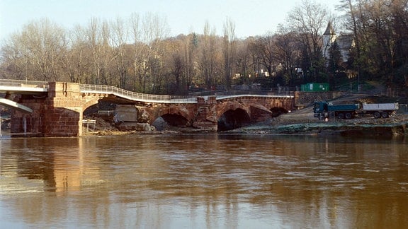 Teilweise eingestürztes oder abgesacktes altes flaches Brückenbauwerk über Fluss