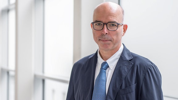 Prof. Dr. Markus Otto, ein schlanker Mann mittleren Alters mit blauem Sakko, weißem Hemd, hellblauer Krawatte. Er hat eine Glatze und trägt eine schwarze Brille.