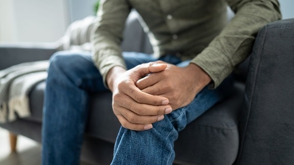 Ein Mann hält sich sein Knie.