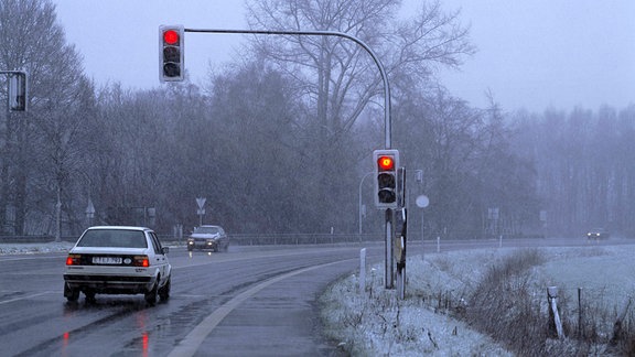 Autos stehen bei schlechtem Wetter an einer roten Ampel.