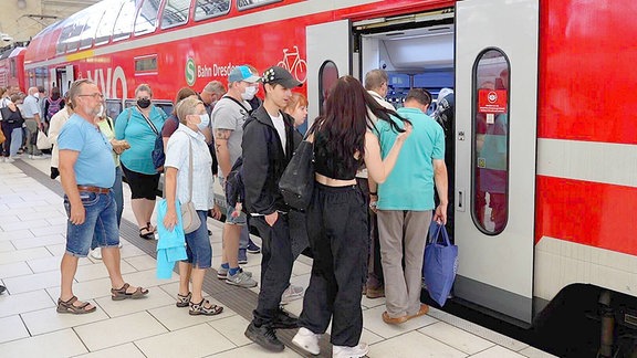 Reisende steigen in einen Regionalzug.