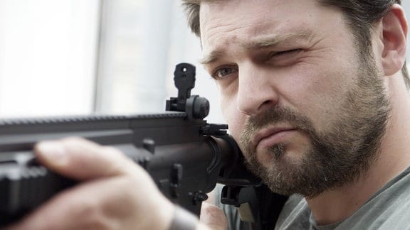 Der Autor, Schauspieler und Blogger Schlecky Silberstein (bürgerlich Christian Brandes) mit einem Schnellfeuergewehr im Anschlag.