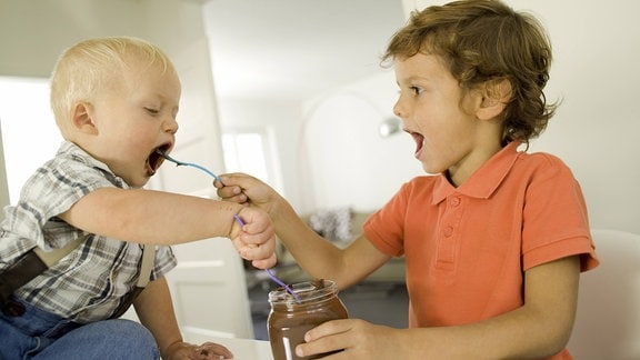 Zwei Jungen löffeln Schokoladencreme
