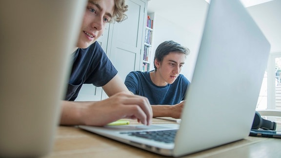 Zwei Teenager arbeiten an Laptop und Tablet