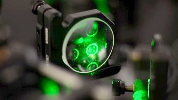 Optik mit grünen Laserstrahlen für ein Experiment zur Koordination von Schwärmen.