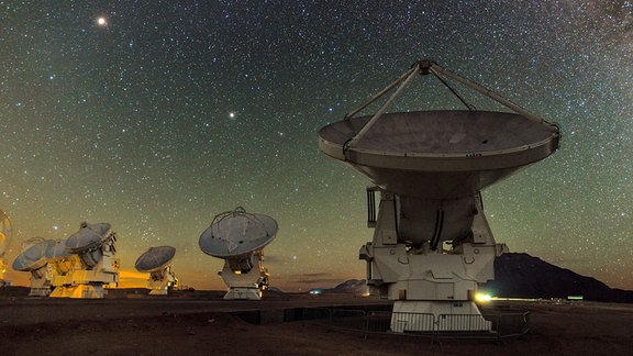 Aas ALMA Radioteleskop in Chile. Im Himmel darüber ist das Zentrum der Milchstrasse zu sehen. 