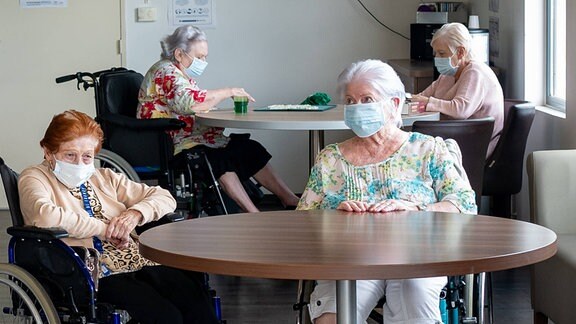 Senioren mit Mund-Nasen-Schutz im Pflegeheim