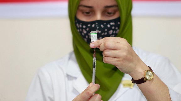 Mitarbeiterin im Gesundheitswesen bereitet Spritze mit dem Impfstoffs Sinopharm vor.