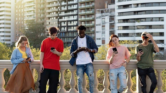 Multikulturelle, urbane Freunde haben Spaß am Handy 