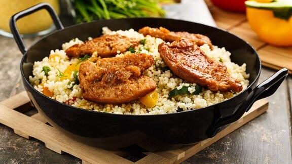Sojaschnitzel auf Couscous und Gemüse in einer Pfanne 