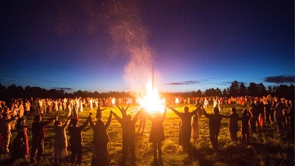 Während einer Sommersonnenwende im Dorf Okunevo versammeln sich die Menschen um ein Lagerfeuer.