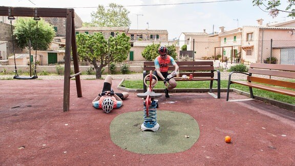 Radfahrer machen eine Pause auf einem Spielplatz
