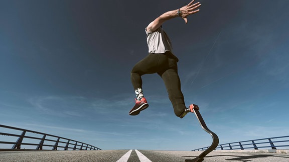 Sprinter mit Beinprothese, auf einer Landstraße