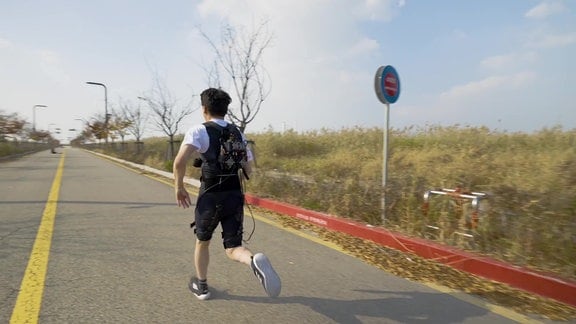 Koreanischer Studienproband, der mit einem Exosuit (Roboter-Unterstützung) sprintet