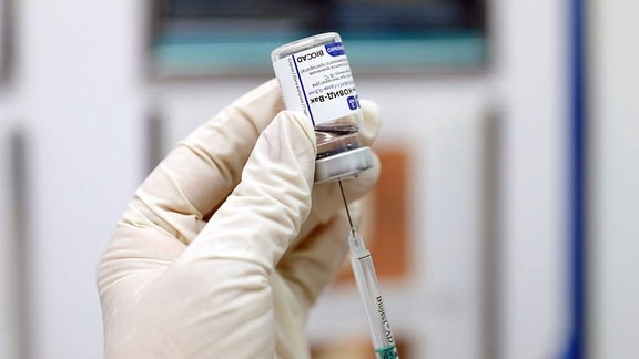 Aufziehen einer Impfspritze mit SputnikV Impfstoff