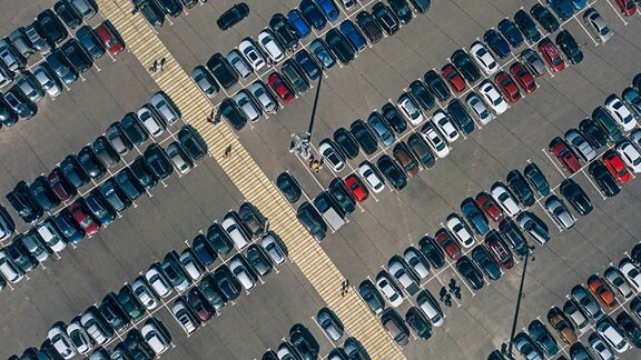 Autos stehen auf einem großen Parkplatz.