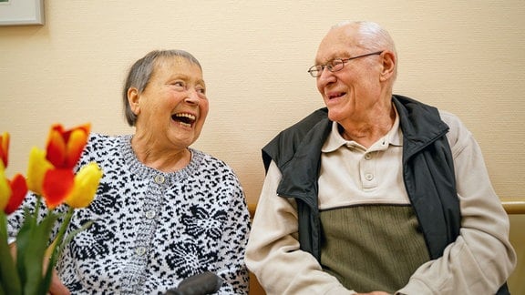 Eine ältere Frau und ein älterer Mann lachen.