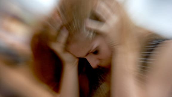 Symbolbild einer Frau mit Kopfschmerzen
