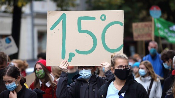 Ein Mann mit Schild 1,5 Grad Celsisus während einer Fridays for Future Demonstration