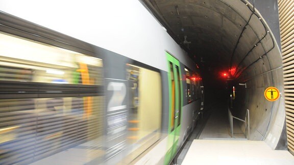 Ein silberfarbener, grüner S-Bahn-Zug der S-Bah Mitteldeutschland fährt vom S-Bahnhof in einen Tunnel ein (Stammstrecke City-Tunnel Leipzig), Bewegeungsunschärfe