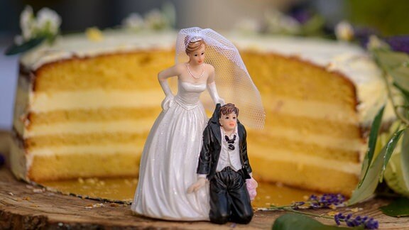 Braut und Bräutigam Figuren vor einer Hochzeitstorte 