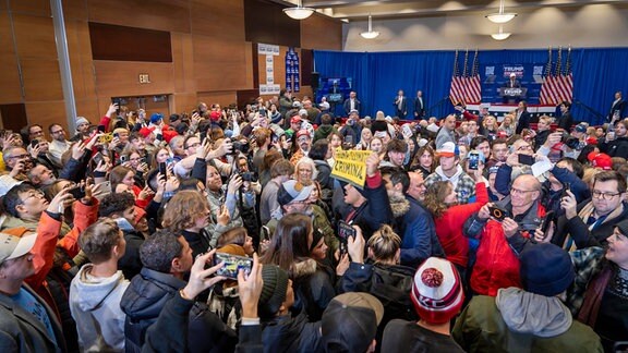Ein Klimademonstrant wird aus Kundgebung für Donald Trump am Simpson College in Indianola Iowa eskortiert