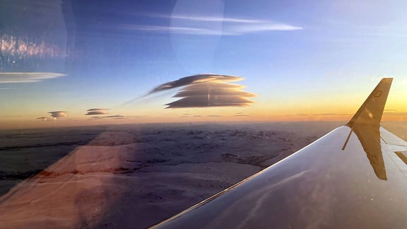 Aufeinander geschichtete Wolken fotografiert durch ein Fenster des Halo-Flugzeugs in der Arktis