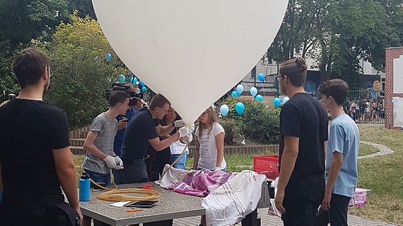 Eine Schülergruppe arbeitet an einem großen Ballon.