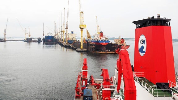 Einfahrt des Forschungsschiffs SONNE in den Hafen von Singapur mit Hafenanlagen im Hintergrund