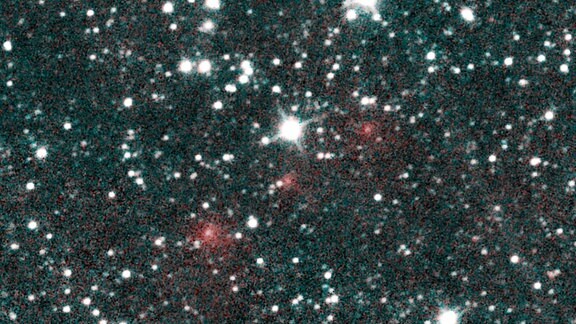Der Komet C / 2020 F3 NEOWISE erscheint als eine Reihe von unscharfen roten Punkten in diesem Komposit aus mehreren wärmeempfindlichen Infrarotbildern