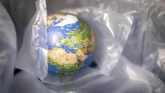 Globus zwischen Plastikverpackungen