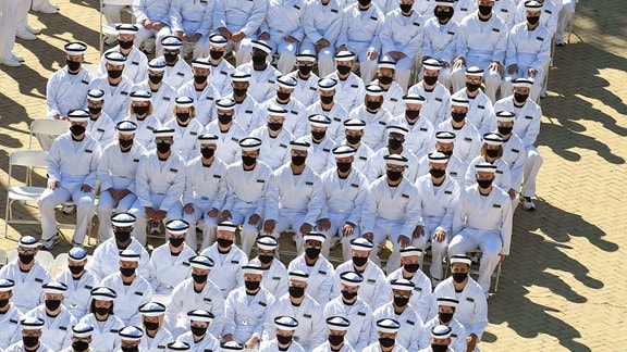 U.S. Navy Zeremonie, bei der die Beteiligten in Uniform Masken tragen