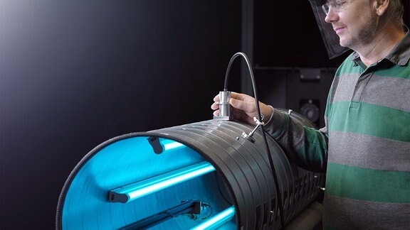 Dr. Peter Sperfeld führt Messungen der UV-C-Strahlung an einem geöffneten Prototyp eines Raumluftreinigungsgerätes durch. 