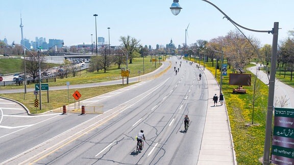Radfahrer und Fußgänger, unterwegs auf für Autoverkehr geschlossener Straße in Toronto.