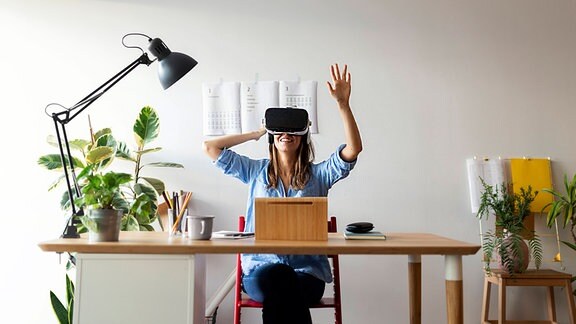 Frau mit VR-Brille am Schreibtisch