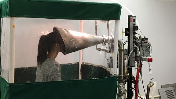 Messapparature namens "Gesundheit-II" - eine Frau steht vor einem großen Metalltrichter in den sie ihr Gesicht gesteckt hat.