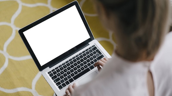 Frau an einem Laptop mit leerem Bildschirm