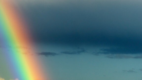 Ein Regenbogen vor Gewitterwolken