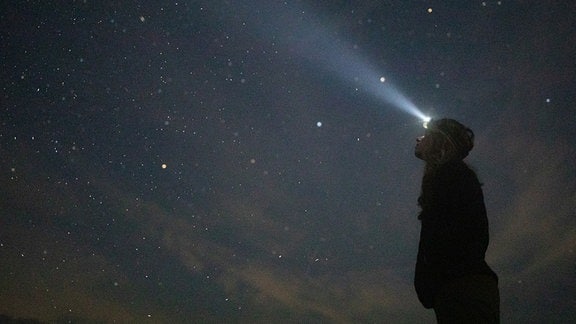 Wissenschaftlerin Dr. Imogen Napper schaut in den Nachthimmel. Sie befürchtet immer mehr Weltraummüll, wenn nicht aktiv gegengesteuert wird.